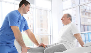 Physiotherapist working with elderly patient in clinic